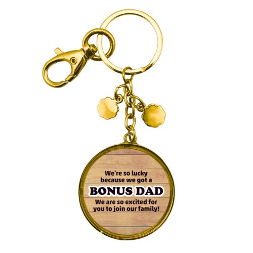 Personalized metal keychain personalized with natural wood pattern and the sayings "We're so lucky because we got a We are so excited for you to join our family!" and "BONUS DAD"