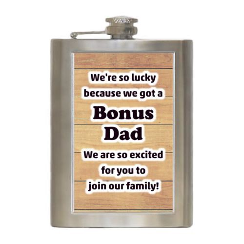 Personalized 8oz flask personalized with natural wood pattern and the saying "We're so lucky because we got a Bonus Dad We are so excited for you to join our family!"