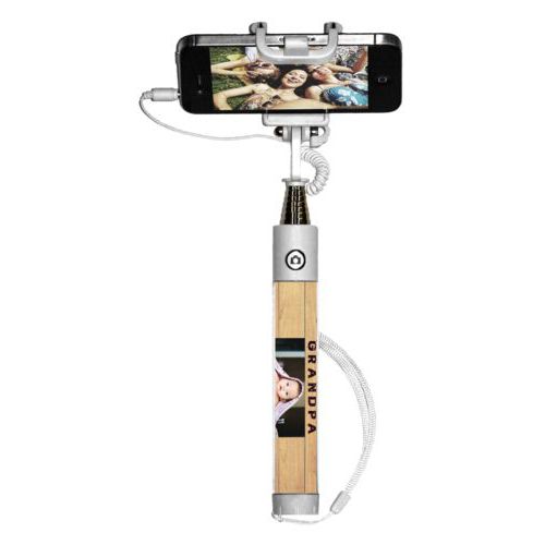 Personalized selfie stick personalized with natural wood pattern and photo and the saying "I got promoted from dad to grandpa"