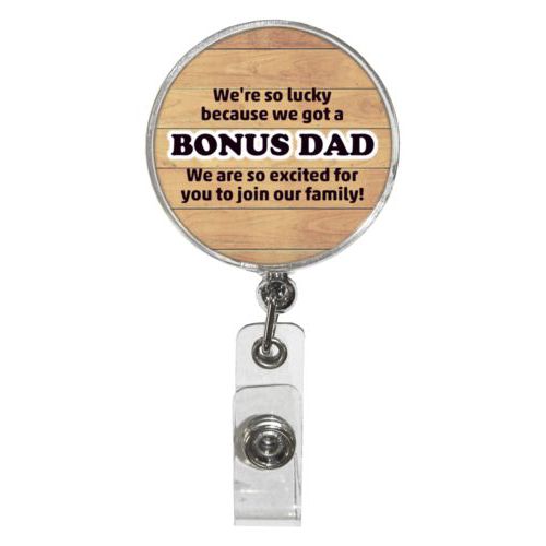 Personalized badge reel personalized with natural wood pattern and the sayings "We're so lucky because we got a We are so excited for you to join our family!" and "BONUS DAD"