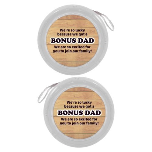 Personalized yoyo personalized with natural wood pattern and the sayings "We're so lucky because we got a We are so excited for you to join our family!" and "BONUS DAD"