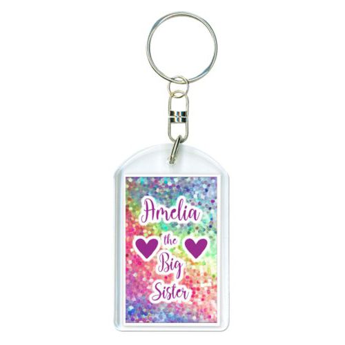Personalized plastic keychain personalized with glitter pattern and the sayings "Amelia the Big Sister" and "Heart" and "Heart"